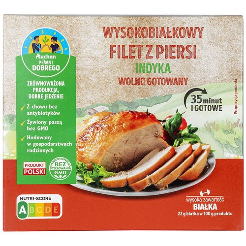 Produkt Auchan: wysokobiałkowy filet z piersi indyka. Opakowanie z grafiką gotowego dania, informacją o braku GMO i antybiotyków.