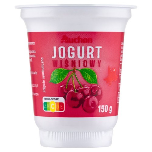 Biały kubek jogurtu wiśniowego Auchan, 150 g. Na etykiecie ilustracja dojrzałych wiśni.