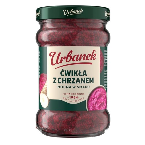 Słoik ćwikły z chrzanem Urbanek z zieloną zakrętką. Na etykiecie widoczne są grafiki buraka i chrzanu oraz mała miseczka z gotową ćwikłą. Opis "Mocna w smaku" i "Firma rodzinna od 1984 Bracia Urbanek".