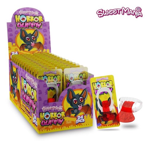 Fioletowo-żółty display Sweet Mania Horror Gummy z grafiką nietoperza, zawierający 24 indywidualne opakowania. Jedno opakowanie poza displayem pokazuje białe zęby wampira z czerwonym żelkiem w kształcie języka.