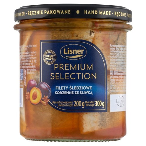 Szklany słoik z filetami śledziowymi Lisner Premium Selection Korzenne ze Śliwką. Etykieta przedstawia śliwki, anyż i cynamon. Masa netto 300g, masa po odsączeniu 200g. Wieczko z napisem "Ręcznie pakowane".