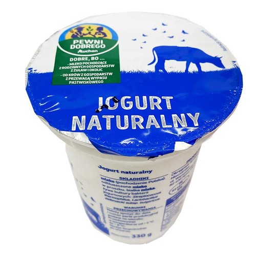 Jogurt naturalny Pewni Dobrego Auchan w białym opakowaniu 330 g. Wieczko z niebieskim tłem, napisem "JOGURT NATURALNY" i krową.