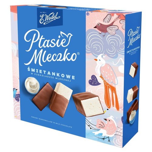 Niebieskie pudełko Ptasiego Mleczka E. Wedel, śmietankowe w czekoladzie mlecznej. Na opakowaniu ilustracje ptaków i chmur. Widoczne pianki w mlecznej czekoladzie, jedna przekrojona, ukazująca białe nadzienie.