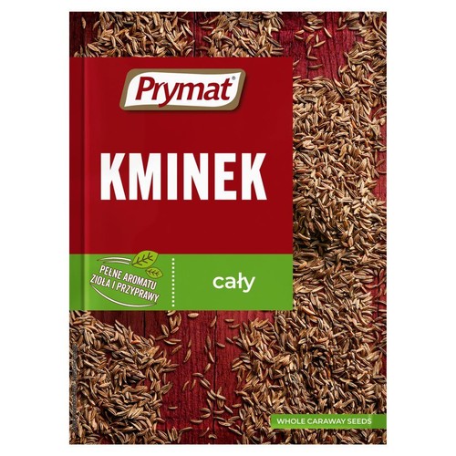 Kminek cały Prymat w czerwono-zielonym opakowaniu. Część nasion rozsypana na drewnianym tle.