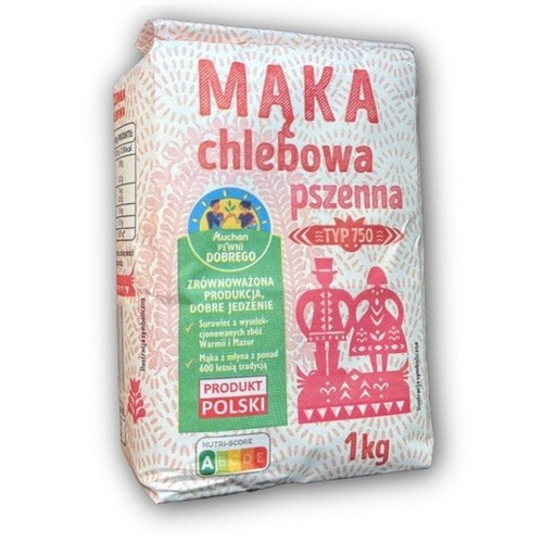 Białe opakowanie mąki pszennej chlebowej Auchan, typ 750, 1 kg. Etykieta podkreśla zrównoważoną produkcję i 600-letnią tradycję młyna.