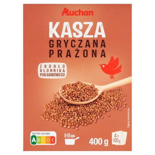 Opakowanie kaszy gryczanej prażonej Auchan, 400 g. Na opakowaniu drewniana łyżka z kaszą. Produkt jest źródłem błonnika pokarmowego.