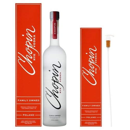 Produkt: wódka Chopin Rye w butelce z matowego szkła z czerwoną zakrętką. Dołączone dwa czerwone opakowania z logo "Chopin Rye Vodka" i opisem "Własność rodzinna, Polska". Obok biała pompka z korkiem, dołączona do zestawu.