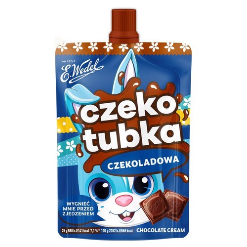 Saszetka E.Wedel Czekotubka Czekoladowa, 25g. Opakowanie jest niebieskie z brązową zakrętką. Przedstawia uśmiechniętego, niebieskiego króliczka, z czekoladowymi plamami i napisem "czekotubka". Na dole informacja "Wygnieć mnie przed zjedzeniem".