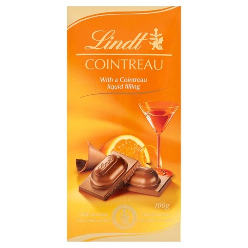 Opakowanie czekolady Lindt Cointreau o wadze 100g. Tło opakowania jest pomarańczowe. Na nim widnieje logo Lindt i nazwa Cointreau. Grafika ukazuje rozłamane czekoladki z płynnym nadzieniem, plaster pomarańczy oraz kieliszek koktajlowy.