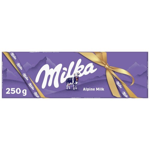 Fioletowe opakowanie czekolady Milka Mleczna Alpejska 250 g. Na opakowaniu duży napis "Milka", grafika krowy z dzwonkiem oraz stylizowane góry. Całość przewiązana złotą wstążką z napisem "Milka", zawiązaną w kokardę.