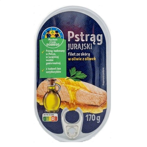 Owalna puszka Pstrąga Jurajskiego Auchan, filet ze skórą w oliwie z oliwek, 170 g. Na etykiecie grafika fileta z oliwą i informacja o hodowli w Polsce, w jurajskiej wodzie geotermalnej, bez antybiotyków.