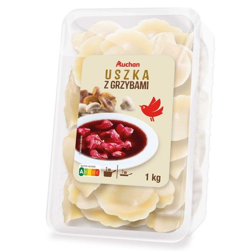 Uszka z grzybami marki Auchan w przezroczystym opakowaniu. Na etykiecie grafika z uszkami w barszczu i grzybami. Waga 1 kg.