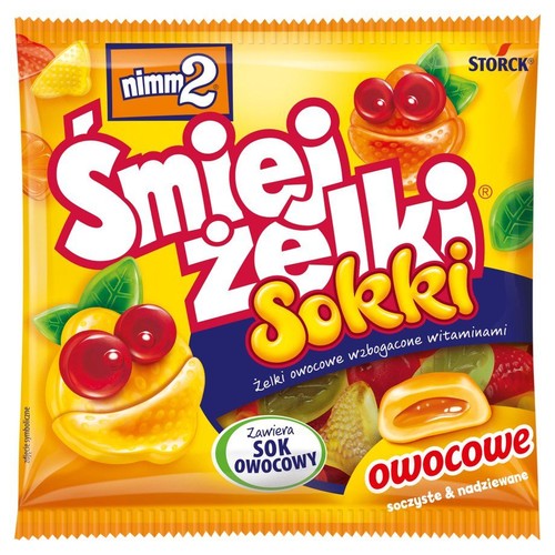 Żółte opakowanie Nimm2 Śmiejżelki Sokki, owocowych żelków wzbogaconych witaminami. Na opakowaniu widoczne są kolorowe żelki w kształcie owoców, niektóre z uśmiechniętymi buźkami, inne pokazujące nadzienie. Zawierają sok owocowy.