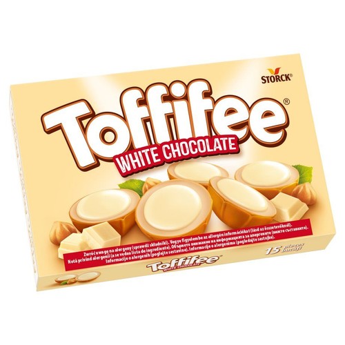 Pudełko Toffifee White Chocolate, zawierające 15 sztuk. Na jasnym tle widnieje nazwa produktu oraz ilustracje karmelowych cukierków z białym kremem, orzechów laskowych i kawałków białej czekolady.