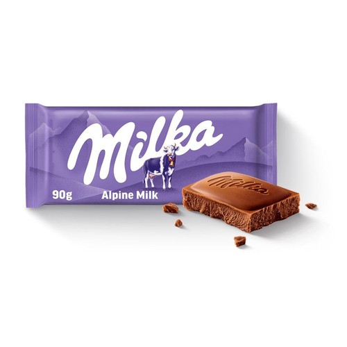 Produkt Milka: fioletowe opakowanie czekolady mlecznej 90g z napisem "Mleko Alpejskie" i grafiką krowy. Przed opakowaniem leży duży, brązowy kawałek czekolady z logo Milka oraz rozsypane wokół niego małe okruszki.