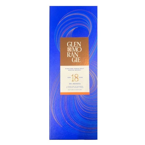 Opakowanie whisky Glenmorangie 18 Years The Infinita. Niebieskie tło z abstrakcyjnymi złotymi wzorami. Na miedzianej etykiecie widnieje nazwa, wiek 18 lat i informacja, że whisky jest destylowana w Szkocji.