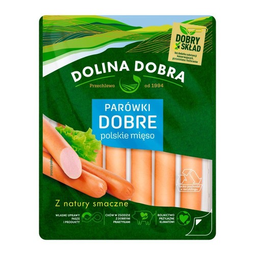 Parówki Dolina Dobra, polskie mięso. Produkt w zielonym opakowaniu z widocznymi parówkami i sałatą. Tacka z recyklingu.