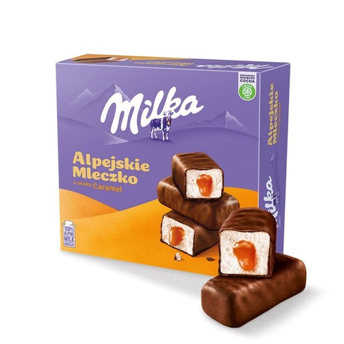 Fioletowe opakowanie Milka Alpejskie Mleczko o smaku karmelowym z logo Milka i krową. Obok leżą trzy czekoladowe batoniki, dwa z nich są przekrojone, ukazując białe mleczko i płynny karmel w środku. Na opakowaniu informacja o 100% mleku alpejskim.