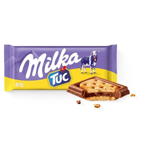 Produkt Milka Tuc 87g w fioletowo-żółtym opakowaniu z nazwą marki i krową. Obok opakowania znajduje się złamany baton, który odsłania warstwę czekolady i słony herbatnik Tuc w środku.
