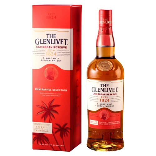 The Glenlivet Caribbean Reserve Single Malt Scotch Whisky w szklanej butelce z czerwoną etykietą. Obok stoi czerwone pudełko z białym panelem, napisem "Rum Barrel Selection" i grafiką palm.