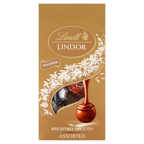 Pudełko czekoladek Lindt Lindor Mieszane. Złote opakowanie z napisem "Lindt Lindor" i "Assorted". Grafika przedstawia płynną czekoladę i dwie pralinki w opakowaniach. Na dole widnieje slogan "Nieodparcie gładkie".