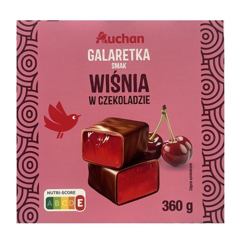 Różowe opakowanie galaretki Auchan o smaku wiśni w czekoladzie, waga 360 g. Na froncie widoczne dwie prostokątne czekoladki z czerwoną galaretką w środku oraz dwie świeże wiśnie na gałązce. W lewym dolnym rogu mały czerwony ptak.