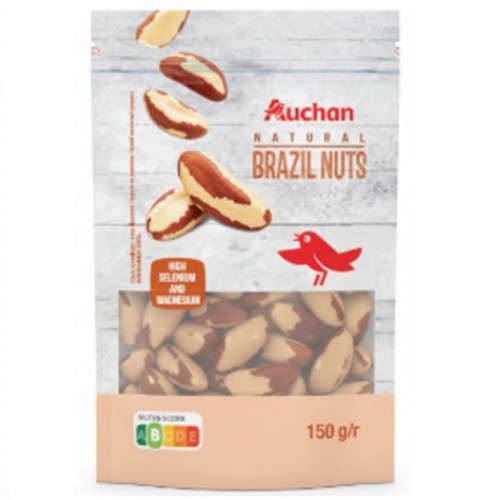 Opakowanie orzechów brazylijskich Auchan Natural, 150 g. Przezroczysta część ukazuje brązowo-białe orzechy. Na górze grafika orzechów i czerwony ptak. Etykieta informuje o wysokiej zawartości selenu i magnezu.
