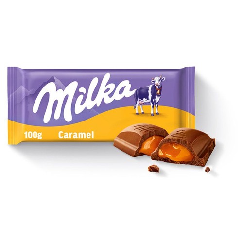 Fioletowe opakowanie czekolady Milka Caramel 100g z białym logo Milka i rysunkiem fioletowo-białej krowy na żółtym tle. Obok leżą dwa przełamane kawałki czekolady mlecznej, ukazujące gęste, złociste nadzienie karmelowe.