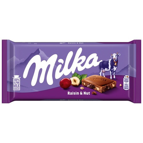 Czekolada Milka Rodzynki i Orzechy w fioletowym opakowaniu o wadze 100g. Na froncie widnieje logo Milka, grafika krowy, a także ilustracje rodzynek, orzechów laskowych i kawałka czekolady. Podkreślono, że to "100% Czekolada z mleka alpejskiego".