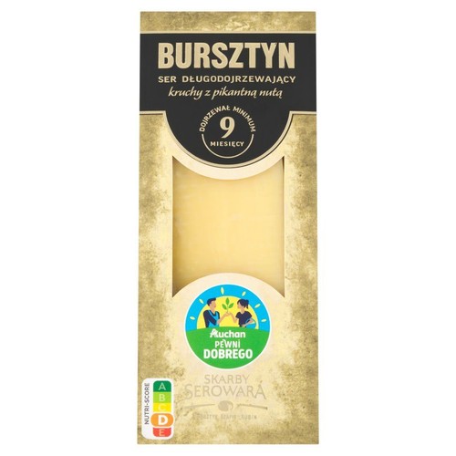 Opakowanie sera Bursztyn, długodojrzewającego, kruchego z pikantną nutą. Ser dojrzewał minimum 9 miesięcy. Widoczny jest blok jasnożółtego sera. Produkt marki Skarby Serowara, dostępny w Auchan.