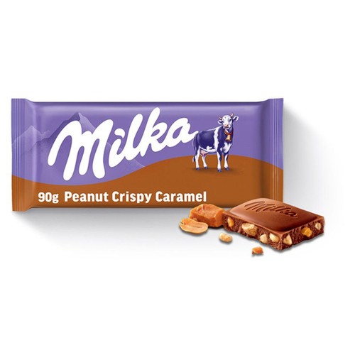 Produkt: czekolada Milka 90g Peanut Crispy Caramel. Fioletowe opakowanie z logo Milka i krową. Obok opakowania widoczny jest kawałek czekolady z orzechami ziemnymi i chrupiącym karmelem oraz rozsypane orzeszki.