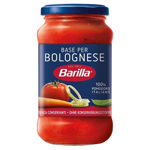 Słoik sosu Barilla Base per Bolognese z czerwoną zawartością i niebieską zakrętką. Na niebieskiej etykiecie widnieje nazwa produktu, logo Barilla oraz grafiki świeżych składników: pomidora, marchewki, cebuli i liścia bazylii. Produkt bez konserwantów.