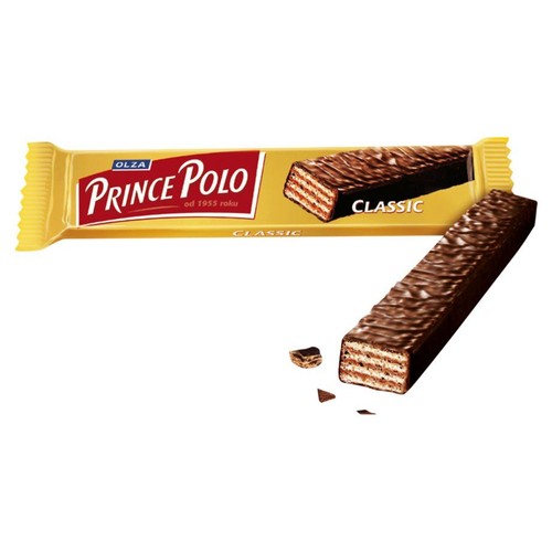 Baton waflowy Prince Polo Classic w żółtym opakowaniu z czerwonym logo. Na opakowaniu widnieje ilustracja batona. Obok leży czekoladowy baton waflowy z widocznymi warstwami chrupiącego wafla i kremu, a także małe okruszki.