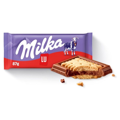 Produkt Milka LU, czekolada z herbatnikiem, 87g. Fioletowe opakowanie z logo Milka i krową. Obok leży złamana tabliczka, ukazująca warstwy czekolady i jasnego herbatnika o falistych brzegach. Wokół rozsypane okruszki.