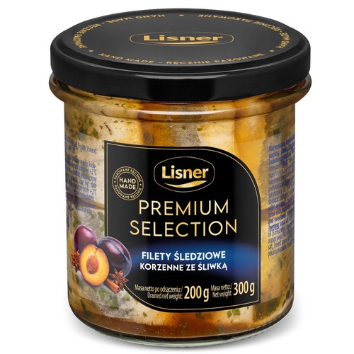 Produkt Lisner Premium Selection: filety śledziowe korzenne ze śliwką, zapakowane w przezroczysty słoik z czarną zakrętką. Etykieta informuje o ręcznym pakowaniu. Waga netto 300g, waga po odsączeniu 200g.