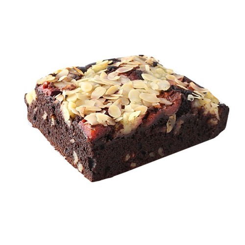 Kawałek czekoladowego brownie z migdałami, orzechami i czerwonymi dodatkami na wierzchu.