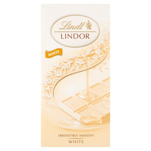 Biała czekolada Lindt Lindor w eleganckim, białym opakowaniu. Na froncie grafika przedstawiająca tabliczkę czekolady z rozlewającym się, kremowym wnętrzem. Opakowanie ozdobione jest subtelnymi, beżowymi wzorami roślinnymi.