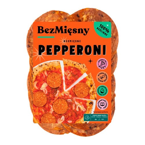 Pomarańczowe opakowanie BezMięsny Bezmięsne Pepperoni. Widoczne okrągłe plastry produktu. Etykieta informuje o 100% roślinnym składzie.