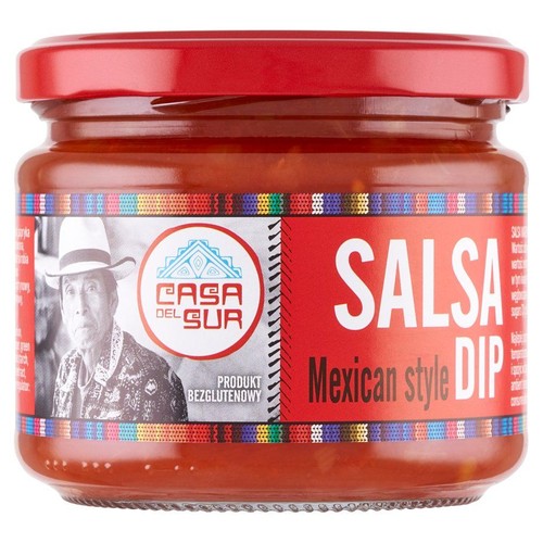 Słoik sosu Casa del Sur Salsa Mexican style DIP. Ma czerwoną zakrętkę i etykietę z kolorowymi wzorami. Na etykiecie znajduje się duży napis "Salsa" oraz informacja "Produkt bezglutenowy" obok portretu mężczyzny w kapeluszu.
